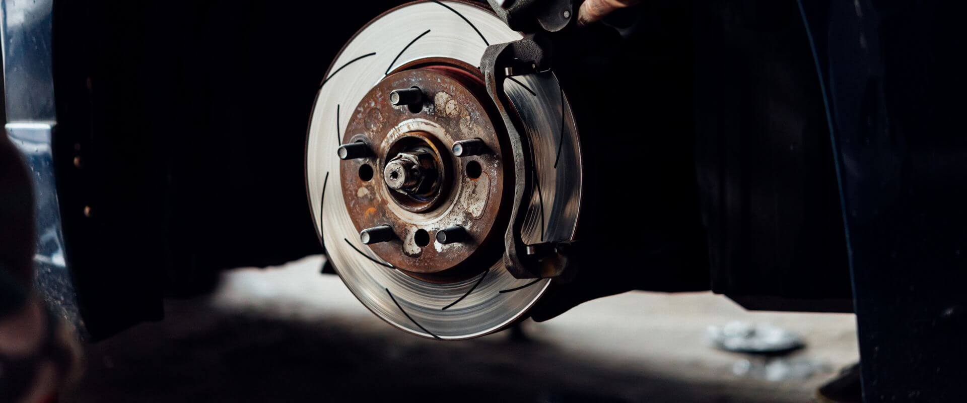 Close-up of a brake rotor and caliper during a brake repair service, emphasizing the importance of vehicle safety and maintenance at Asher Auto Care in Dallas, TX.