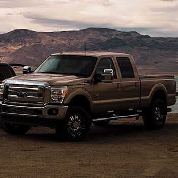 Ford diesel truck parked in a rugged outdoor setting, showcasing its durability and suitability for heavy-duty tasks, relevant to diesel vehicle maintenance and performance tips.