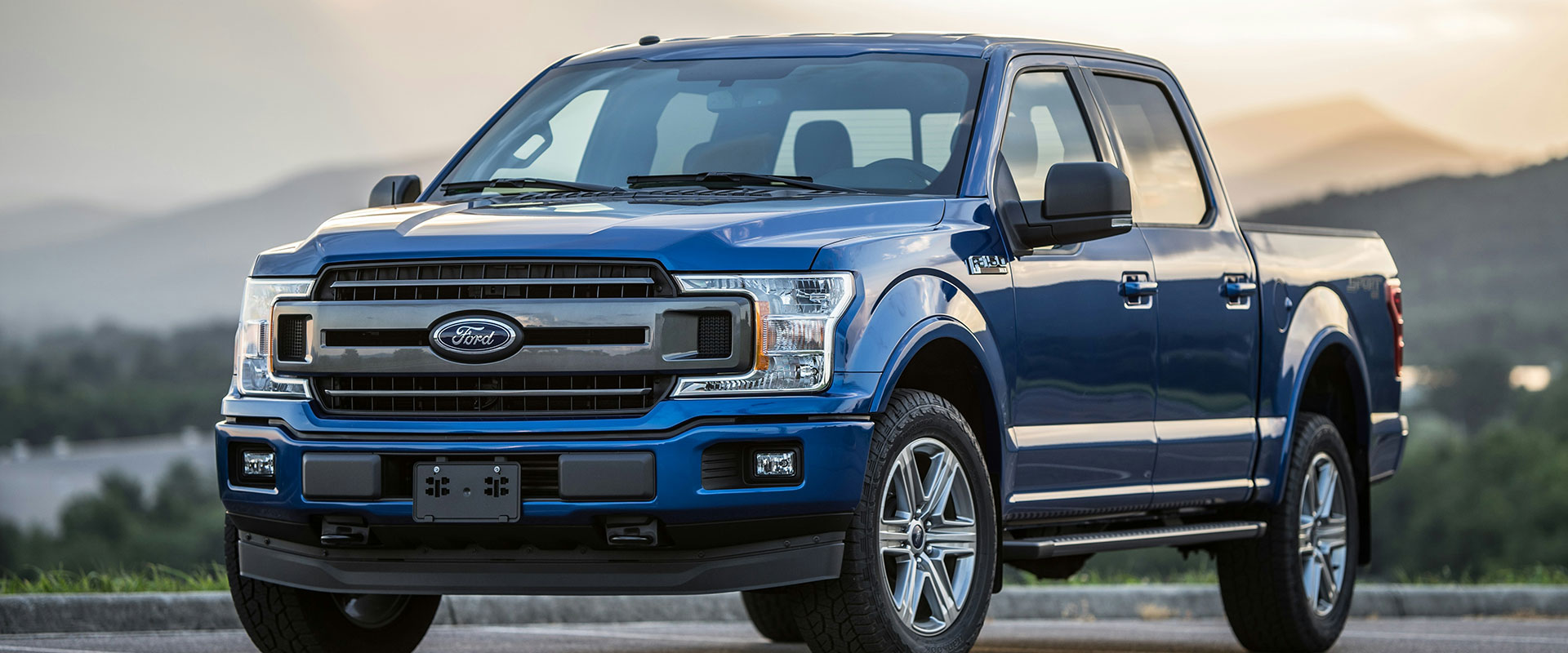 Blue Ford F-150 truck parked in scenic outdoor setting, representing diesel vehicles serviced at Asher Auto Care in Dallas, TX.