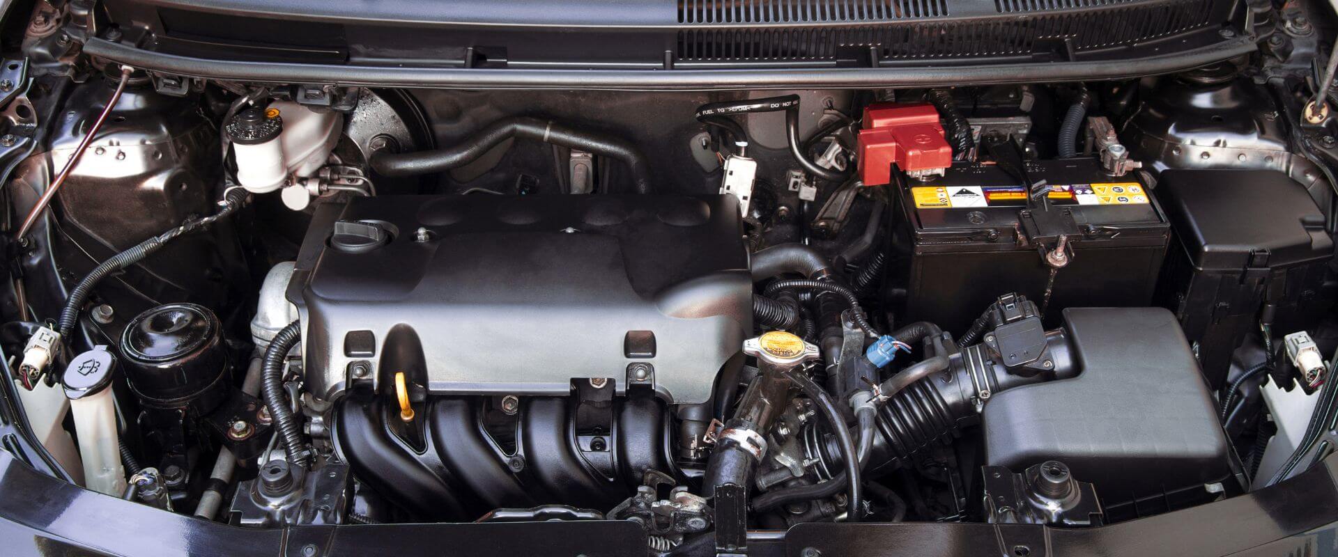 Engine compartment showcasing essential components like the engine block, battery, and various hoses, emphasizing engine repair services in Dallas, TX.