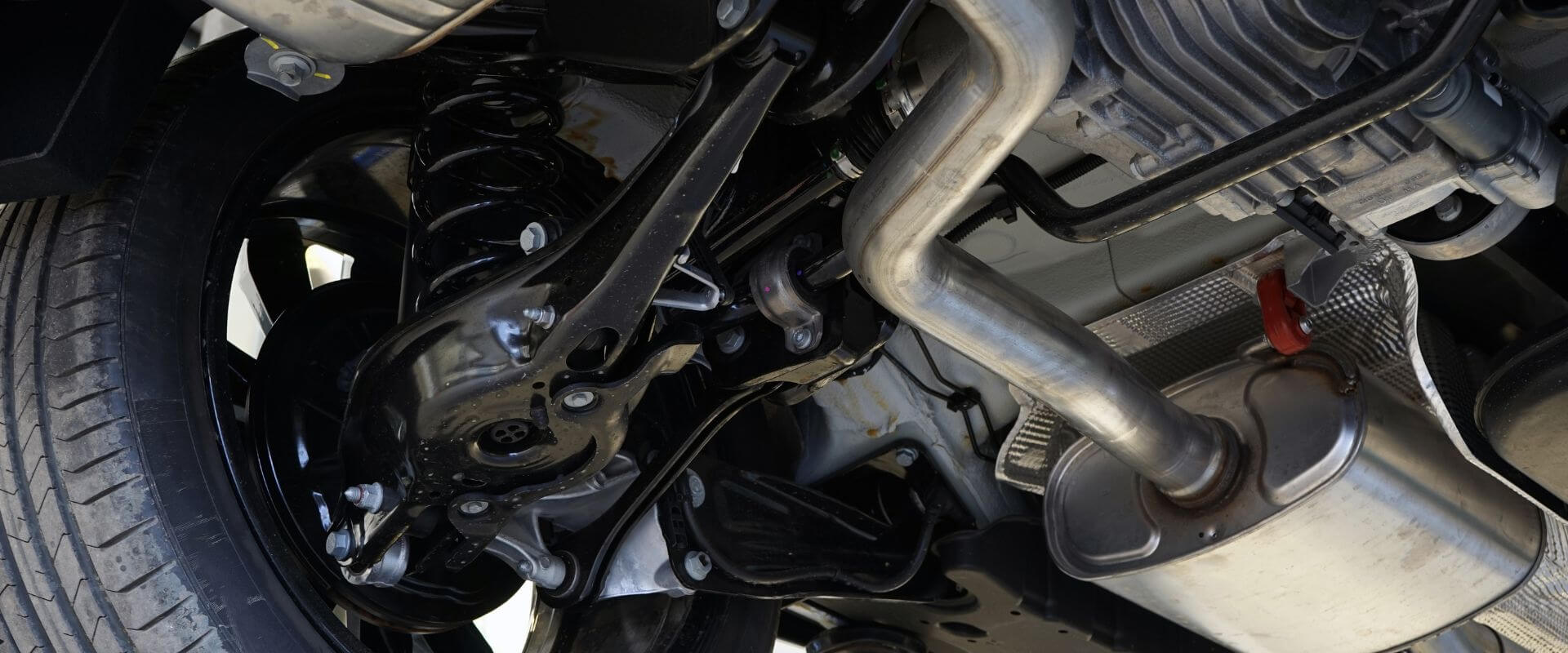Close-up of vehicle suspension system components, including shocks, springs, and control arms, highlighting the importance of suspension repair for safe driving in Dallas, TX.
