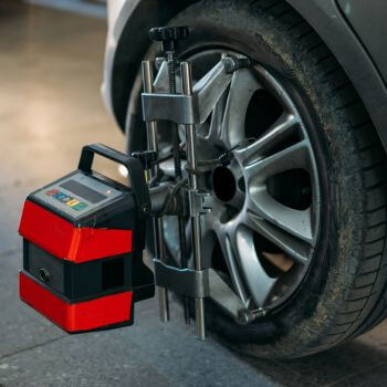 Wheel alignment machine attached to a vehicle's tire, showcasing precision equipment used for tire alignment and maintenance services at Asher Auto Care in Dallas, TX.