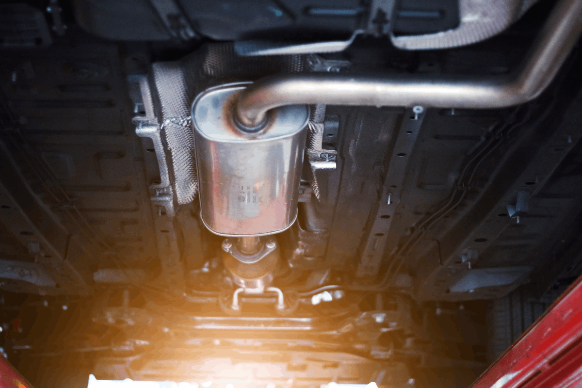 Exhaust system components under a vehicle, highlighting the muffler and pipes, relevant to exhaust maintenance tips for optimal vehicle performance.